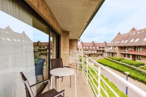 un balcone con tavolo e sedie su un edificio di Roya G7 a Koksijde Altre 12 foto