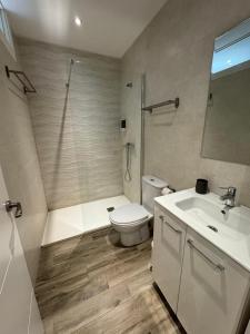 a bathroom with a toilet and a shower and a sink at Apartamentos EL SERRÓN Colombres in Colombres