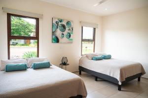 Ένα ή περισσότερα κρεβάτια σε δωμάτιο στο La Perla Cozy 3BR sleeps 10 Hacienda Pinilla +36 φωτογραφίες