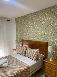 a bedroom with a bed and a green wall at Cazorla House in Cazorla