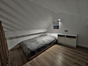a small bedroom with a bed and a desk at Apartamenty nad Kamiennym Potokiem 2 in Szczytna