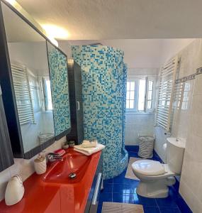 a bathroom with a red sink and a toilet at Sea Lullaby in Drymonas +63 photos