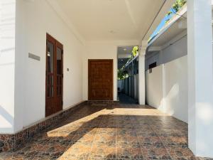 an empty hallway with a door and a tile floor at Birds Nest in Trincomalee