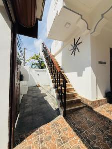 a staircase in a house with a clock on the wall at Birds Nest in Trincomalee
