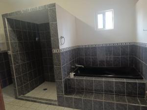 a bathroom with a tiled shower with a window at Casa paraiso in Maito +24 photos