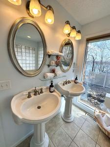 een badkamer met twee wastafels en twee spiegels bij Lakehouse Wpools, Hottub, Dock, Sauna,playground in Sunrise Beach