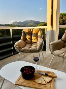 a table with a glass of wine and a couch at Maravilloso Apto en el Pantano de San Juan in San Martín de Valdeiglesias