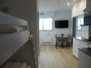 Cette chambre comprend une cuisine avec une table et une télévision. dans l'établissement Arcachon Pereire bord de plage, à Arcachon