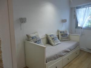 Cette chambre comprend un banc avec des oreillers et une fenêtre. dans l'établissement Arcachon Pereire bord de plage, à Arcachon