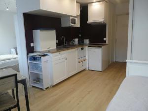 une cuisine avec des armoires blanches et un plancher en bois dans l'établissement Arcachon Pereire bord de plage, à Arcachon 23 autres photos