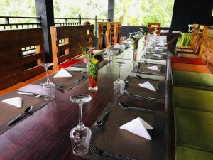 a long table with glasses and napkins on it at The Papa Resort Ambuluwawa in Balatgomuwa