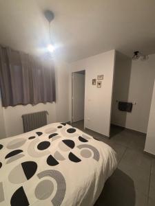 a bedroom with a bed with a black and white comforter at Appartement en aveyron in Aubin