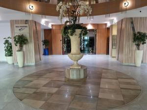 eine Lobby mit einer großen Vase mit Blumen darin in der Unterkunft Rin Elegance Apartament in Bukarest