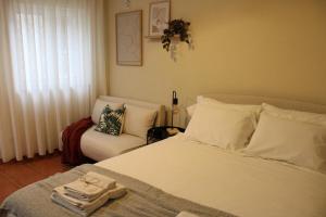 a bedroom with a white bed and a chair at Carmo guestroom in Tabuaço