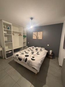a bedroom with a bed with a black and white comforter at Appartement en aveyron in Aubin +4 photos