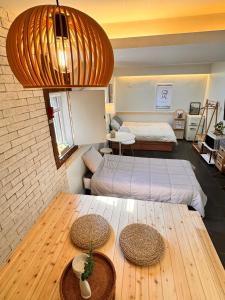 a room with two beds and a wooden table at Vax Doroci Stay in Kuri