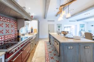 a large kitchen with blue cabinets and a large island at Beautiful property near Fayence in Saint-Paul-en-Forêt