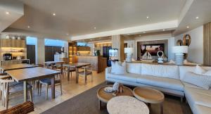 a living room with a couch and a table at Waves of Grace Seafront Villa in Herolds Bay