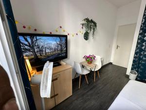 a room with a television and a table and chairs at Delight room 1st door in Nice