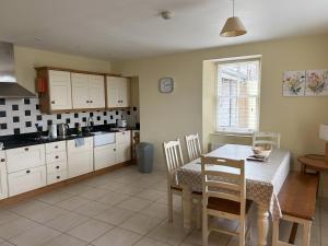 a kitchen with a table and a table and chairs at 5 Bank House in Schull