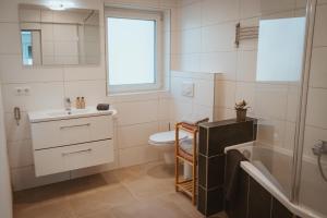 a bathroom with a sink and a toilet and a tub at Little Break in Röfingen