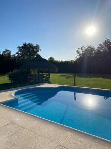 a large blue swimming pool with an umbrella at La Calma casa quinta in Capilla del Señor