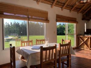 a dining room with a table and some windows at La Calma casa quinta in Capilla del Señor