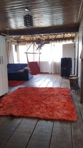 a room with a red rug on a wooden floor at casa da meg in Tiradentes