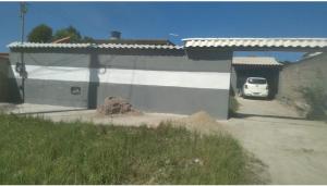 a white van parked in a garage next to a building at Casa raízes do bem in São Pedro da Aldeia