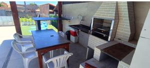 a small kitchen with a table and a stove at Casa raízes do bem in São Pedro da Aldeia