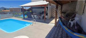 a swimming pool in front of a house at Casa raízes do bem in São Pedro da Aldeia