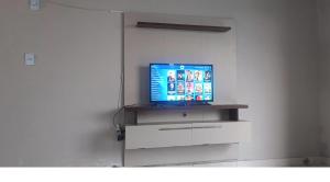a television sitting on top of a dresser at Casa raízes do bem in São Pedro da Aldeia
