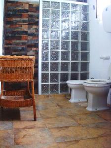 a bathroom with a toilet and a chair and a wall at Astonishing house by the beach CASA AZUL in Playa Verde