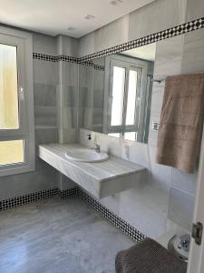 a white bathroom with a sink and a mirror at Sol Puerto Apartamento en Almerimar in Almerimar