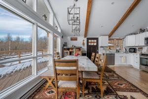 a kitchen with a table and chairs and windows at Tranquility Redefined in the Heart of the Catskills in Jewett
