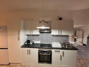 een keuken met witte kasten en een kookplaat oven bij Casa rural Martín in Granada +7 foto's