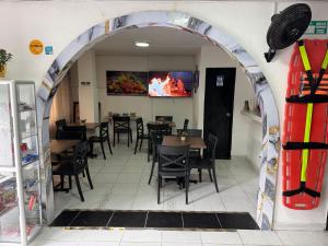 einen Torbogen in einem Restaurant mit Tischen und Stühlen in der Unterkunft Hotel San Juan 70 Express Medellin in Medellín + 71 Fotos