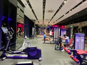 a gym with people exercising on treadmills and machines at Well-Shaped Suites At STAR KLCC in Kuala Lumpur