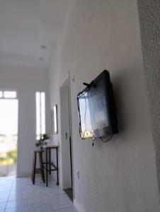 a television hanging on a wall in a room at salvador, quartos com ar centro,pelourinho in Salvador