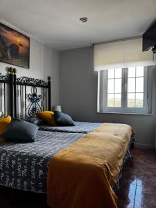ein Schlafzimmer mit zwei Betten und zwei Fenstern in der Unterkunft Apartamentos Casa Carola in Viodo