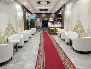 a aisle with white chairs and a red carpet at شقق الزمرد للشقق المخدومة in Al Khobar