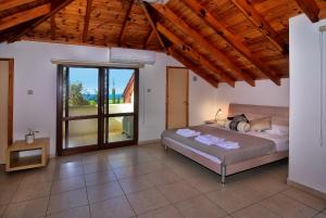a bedroom with a bed and a large window at Villa Margarita in Polis Chrysochous +37 photos