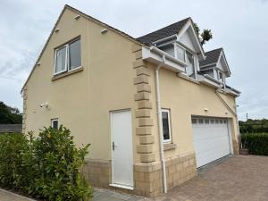 a house with a white garage door at Open plan Studio Apartment in Royal Wootton Bassett