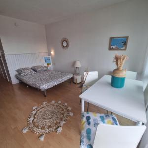 un salon avec un lit et une table dans l'établissement COSY STUDIO BENODET vue mer accès direct plage Thalasso Casino, à Bénodet