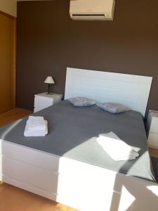 a white bed with two towels on top of it at Monte Açores in Ferreira do Alentejo
