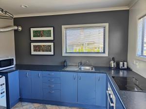 a kitchen with blue cabinets and a sink at Ohakune Peak Retreat Unit 1 in Ohakune +14 photos