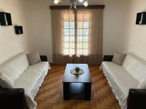a living room with two couches and a coffee table at Christodoulos Villa in Agios Georgios
