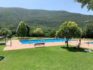 a swimming pool in a park with a bench and trees at Casa Balcón de Los Pirineos - Gavín Biescas in Gavín +65 photos