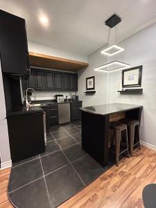 a kitchen with a black island in a room at Cosy Quinpool Rd - 2 Bedroom Apartment in Halifax