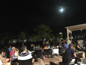 Eine Menschenmenge, die nachts an Tischen sitzt. in der Unterkunft SALINAS DE VERA APARTAMENTO in Vera + 25 Fotos